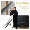 A man in a black gi holds a traditional katana sword, with a large blade and a smaller sword displayed nearby.