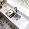 A stainless steel kitchen sink and faucet installed in a modern cabinet with a white window sill and tile backsplash.
