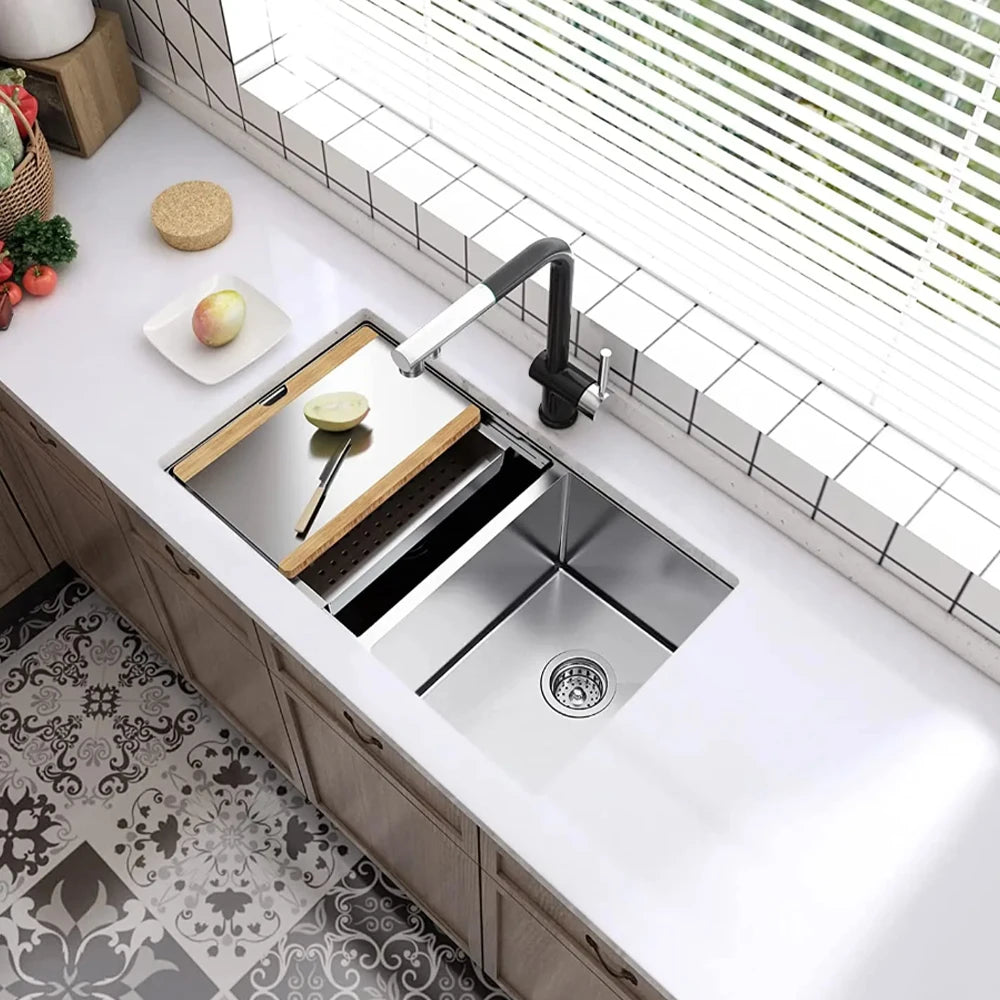 A stainless steel kitchen sink and faucet installed in a modern cabinet with a white window sill and tile backsplash.