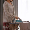 A woman is ironing fabric using a heat-resistant wool felt ironing mat.