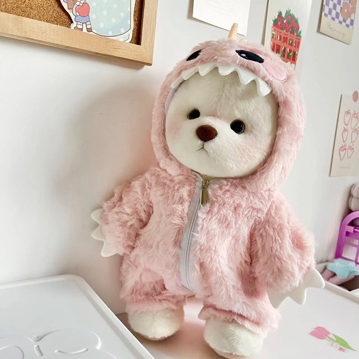 A fluffy pink dinosaur jumpsuit outfit for a medium teddy bear doll.