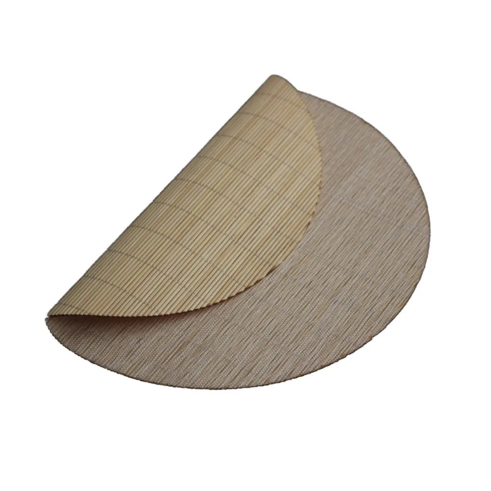 A round, light tan bamboo tea mat showing a layered texture and natural woven pattern.