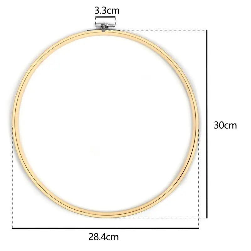 A circular bamboo embroidery hoop with a gold-colored frame and an adjustable screw mechanism.