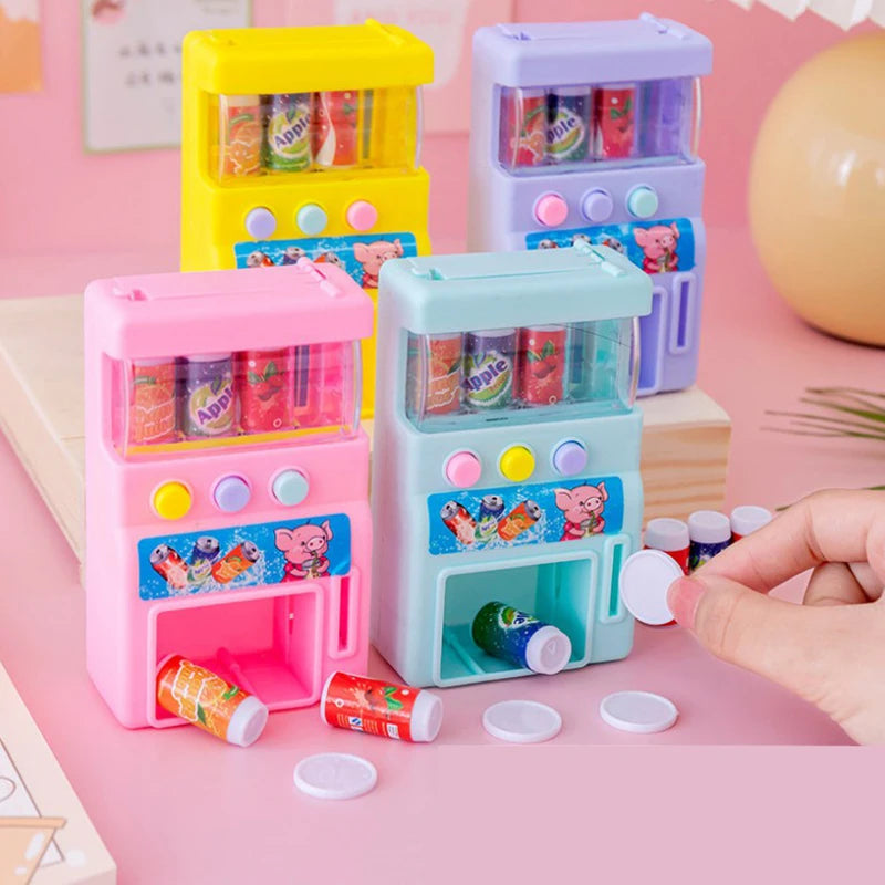 A set of colorful interactive vending machine toys featuring plastic bottles and play coins on a pink surface.