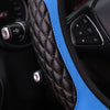 Close-up of a black quilted steering wheel cover with a bright blue accent stitching and controls.