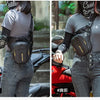 A woman wearing a gray shirt and jeans is carrying a black waterproof motorcycle hip pack.