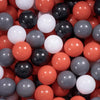 A close-up view of a large pack of colorful plastic balls in various shades of red, black, white, and gray.