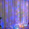 Purple and pink LED curtain lights illuminating a draped background for event decor