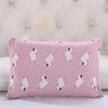 A pink cartoon pillow featuring a white mouse design on a quilted background.