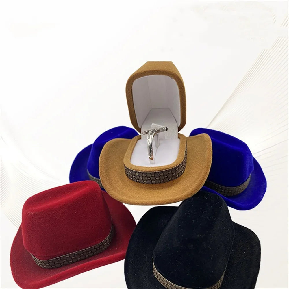 A velvet cowboy hat storage box with a secure closure, featuring a tan felt hat and blue velvet accessories.