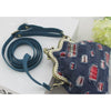 A dark blue canvas shoulder strap with a plaid pattern is shown next to a fabric bag.