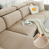 A beige jacquard elastic sofa slipcover featuring a woven texture and decorative pillows.