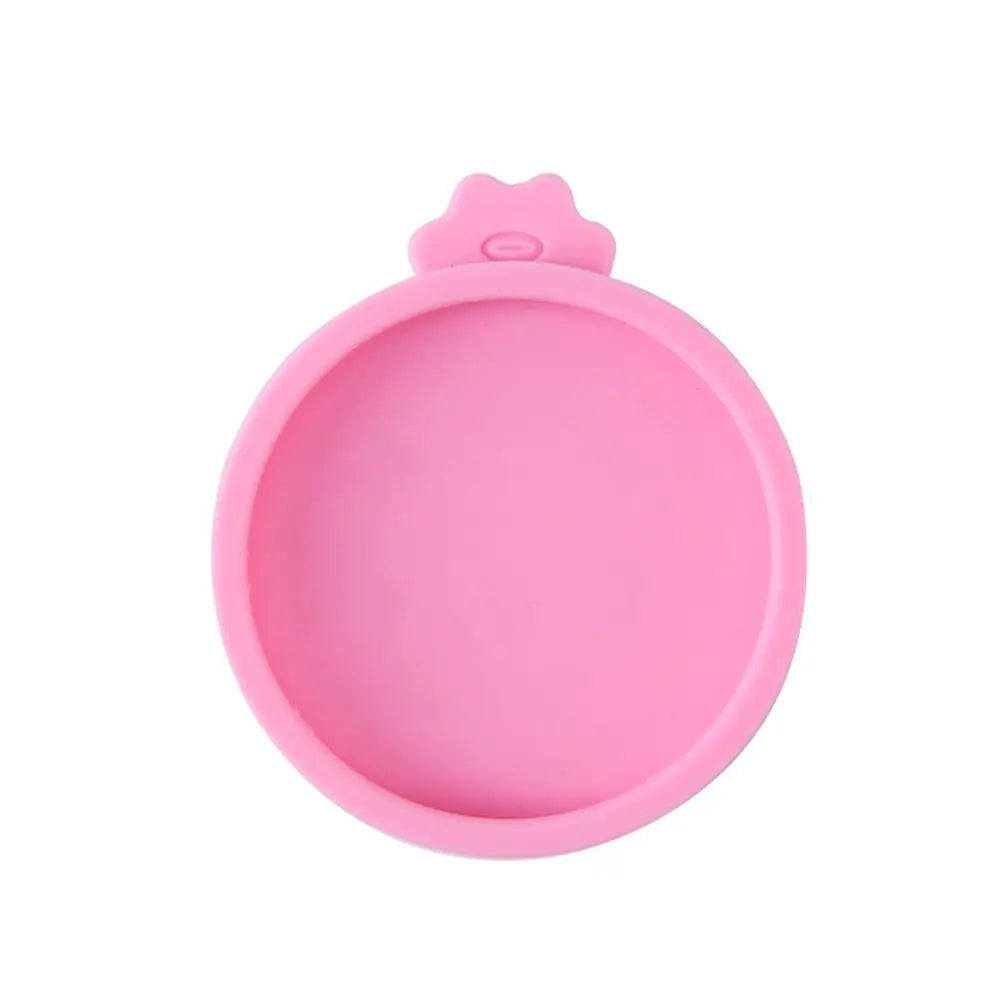 A pink reusable silicone food storage lid with a small opening.