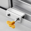 A silver aluminum alloy sliding window lock with a yellow plastic hex key is installed in a white window frame.