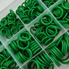 A variety of green automotive air conditioning O-ring gaskets are arranged in a clear plastic tray.