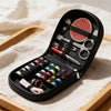 A black compact travel sewing kit with various tools and thread spools is displayed on a wooden tray.