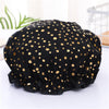 Black elastic shower cap with gold polka dots shown on a white surface.