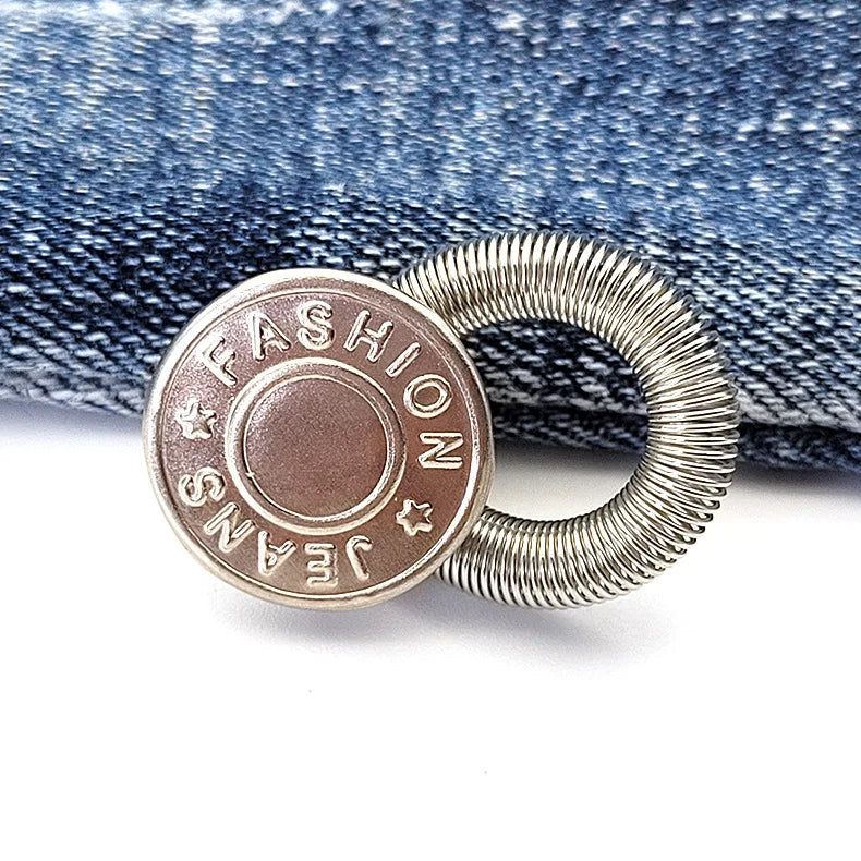 Silver extender buttons with a round charm featuring the word FASHION and jeans symbols, placed on denim fabric.