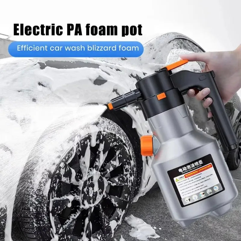 A hand is using a silver electric foam pot to apply blizzard foam onto a car wheel during washing.