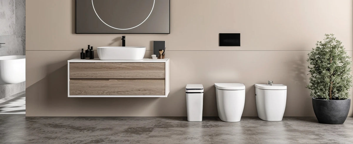 A bathroom vanity featuring a white vessel sink and wooden cabinet, with a modern toilet and a potted plant visible.