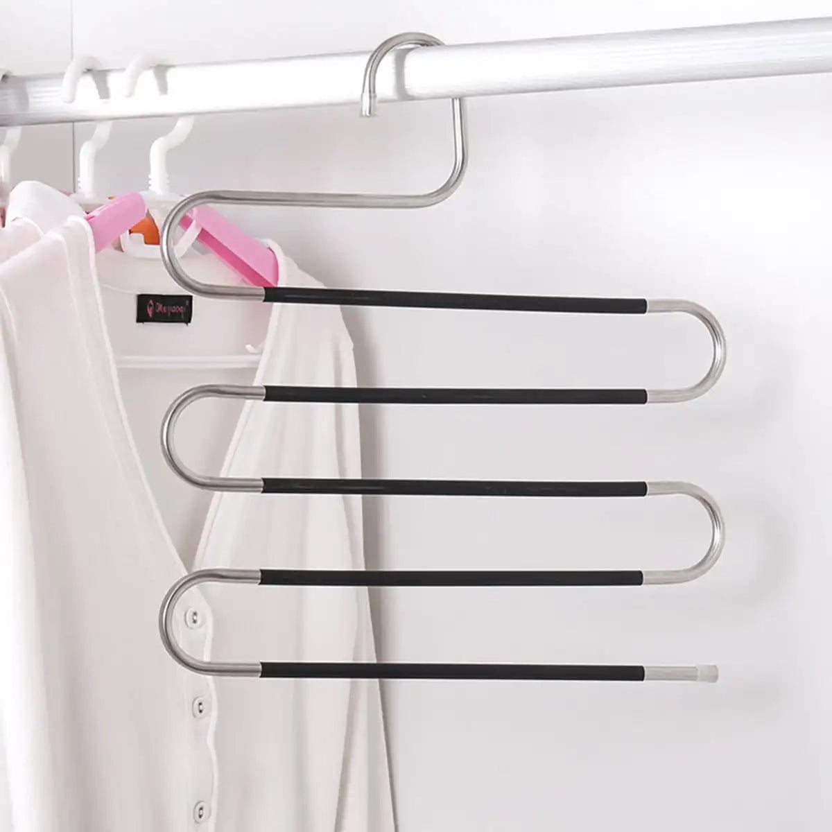 A silver S-shaped pants hanger with multiple black bars is displayed on a white closet rod.