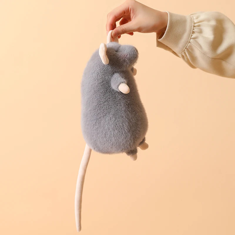 A light gray plush mouse stuffed animal with a white keychain loop being held by a hand.