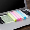 A silicone keyboard cover with multiple colored silicone skins is placed on a laptop keyboard.