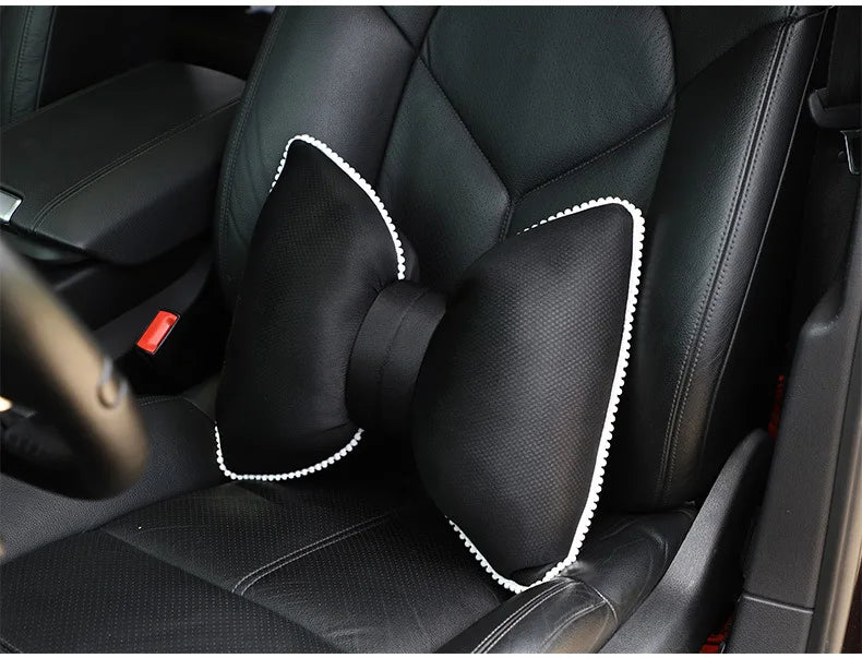 Black silky bow car headrest pillow with waist cushion set shown in a vehicle interior.