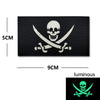 Black embroidered patch featuring a white skull and crossed swords design with luminous accents.