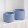 A light blue handwoven cotton rope storage basket used for desk organization.