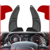 Black shift paddle extenders mounted on a car steering wheel visible through the dashboard.