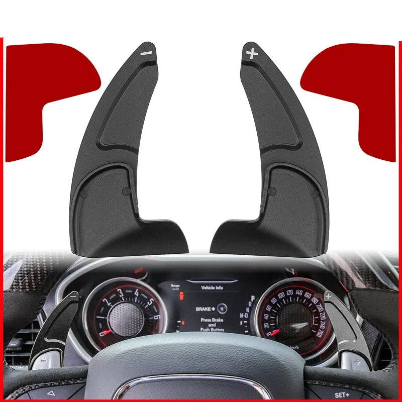 Black shift paddle extenders mounted on a car steering wheel visible through the dashboard.