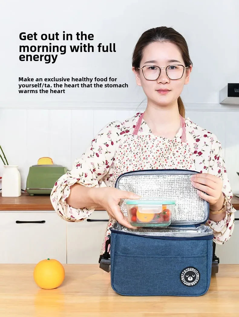A woman holds an insulated lunch bag with a shoulder strap, demonstrating a healthy food product.