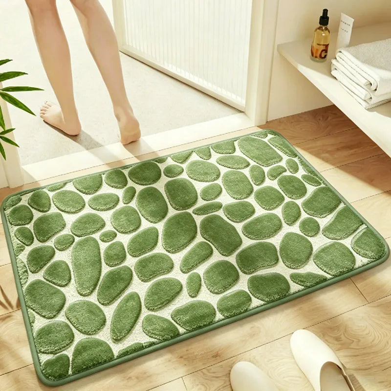 A rectangular green plush non-slip bathroom rug with a pebble texture placed on a wooden floor.