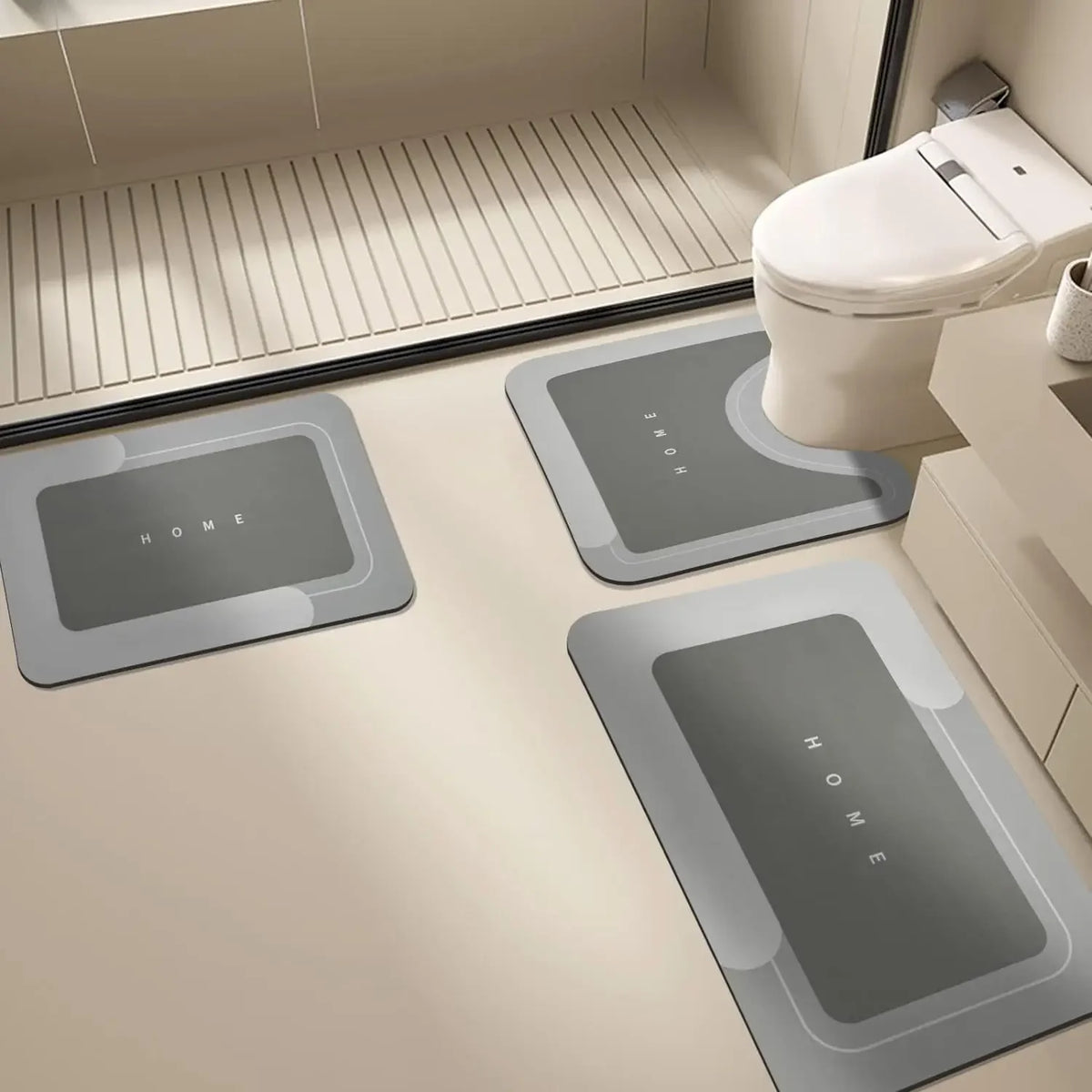Three rectangular floor mats with the word HOME printed on them placed in front of a white toilet.