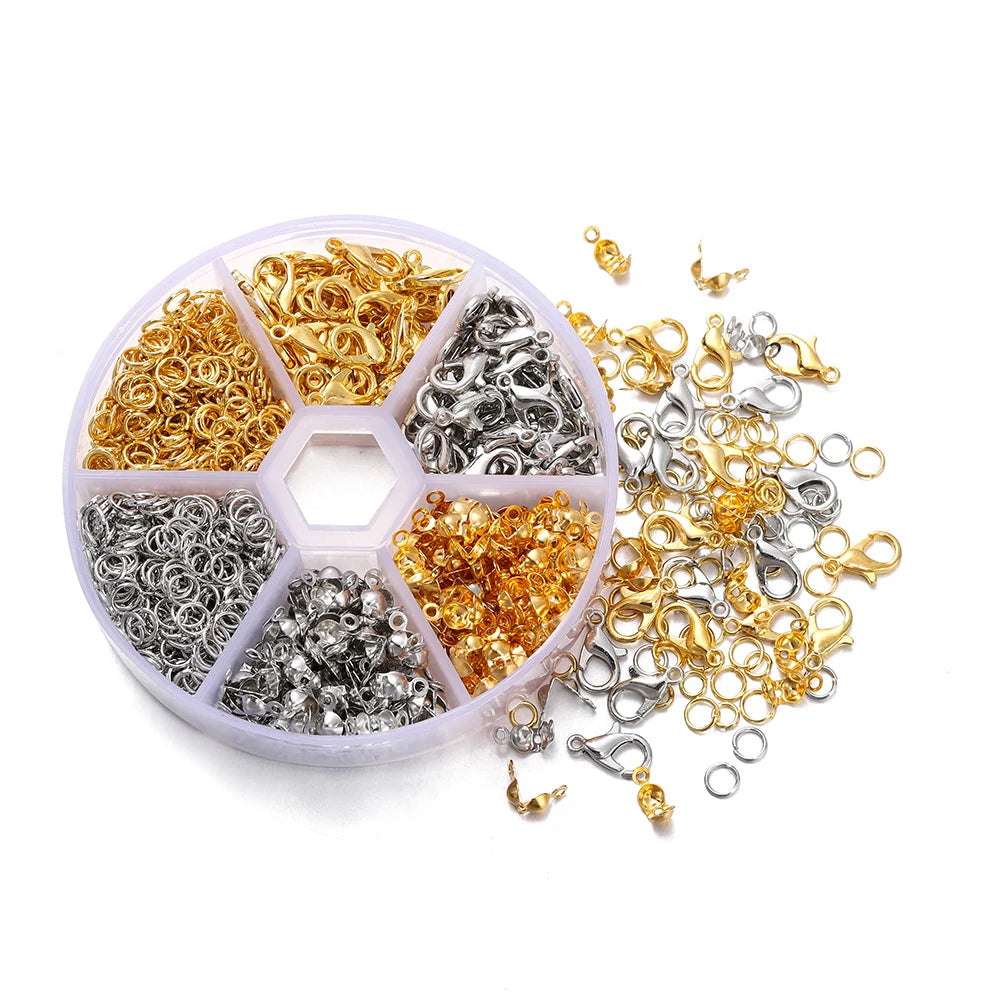 A collection of gold and silver jewelry findings including lobster clasps, jump rings, and crimps organized in a clear plasti
