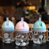 A set of clear plastic straw cups with handles in pastel colors pink and mint green sitting on a dark surface.