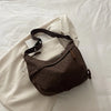A dark brown leopard print crossbody bag resting on a white blazer or jacket.