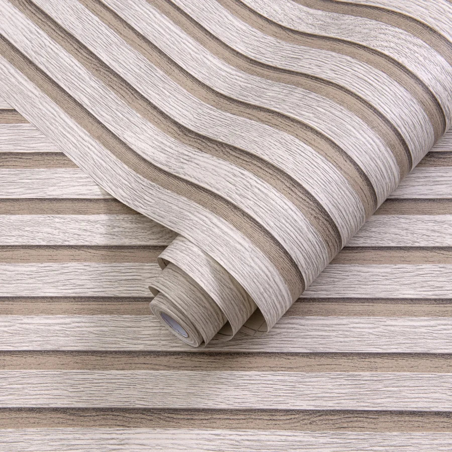 Roll of self-adhesive 3D wall stickers with a wavy texture on a wooden background.