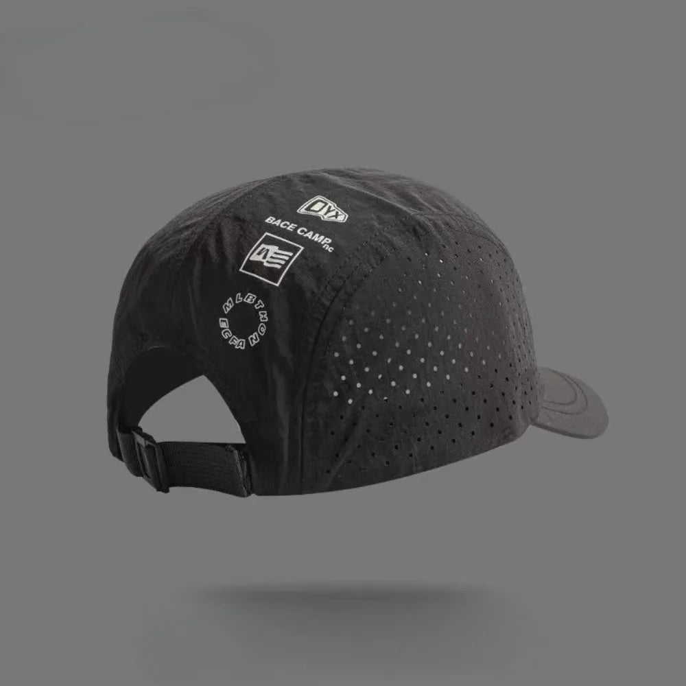 A black Dyx base camp baseball cap with a mesh front and a curved brim is shown against a gray background.