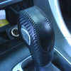 Close-up of a black carbon fiber gear shift knob cover for a vehicle interior.