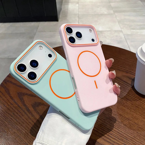 A pink phone case with an orange circular design is displayed on a wooden table.