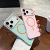 A pink phone case with orange circular designs is displayed on a wooden table.
