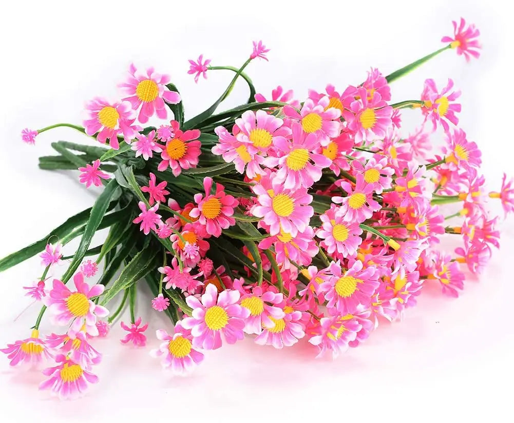 Ein Strauß leuchtend rosa und magentafarbener künstlicher Margeriten mit gelben Mittelpunkten.
