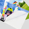 A child wearing a yellow helmet and goggles is smiling while holding a colorful kite against a blue sky.