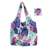 A white and purple tropical leaf patterned reusable nylon shopping tote bag.