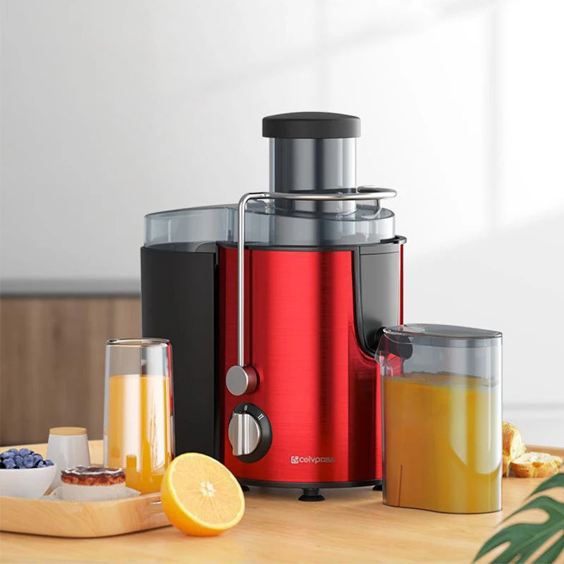 A red and black centrifugal juicer appliance with a stainless steel feed tube and a glass juice container on a wooden surface