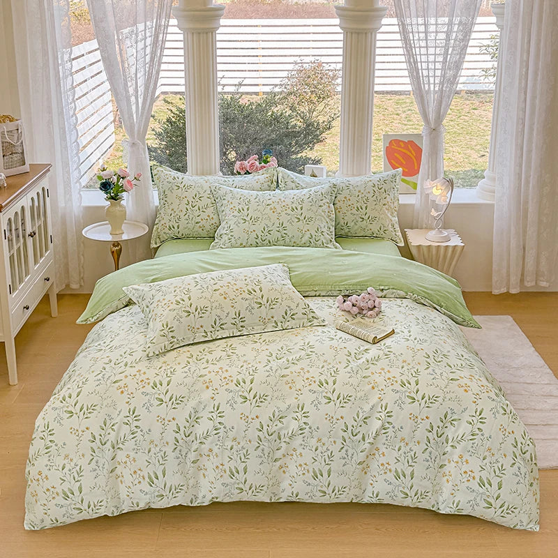 A light green printed duvet cover set with matching pillows displayed on a bed in a bright room.