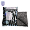 A package of black microfiber cleaning cloths with white stripes is shown next to a folded gray towel.