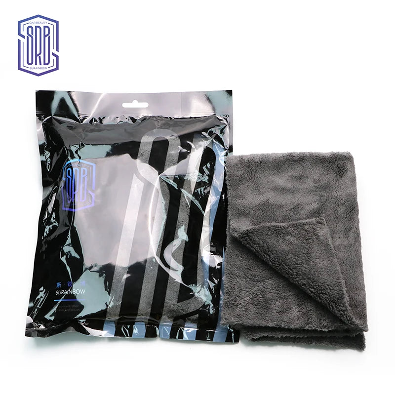 A package of black microfiber cleaning cloths with white stripes is shown next to a folded gray towel.